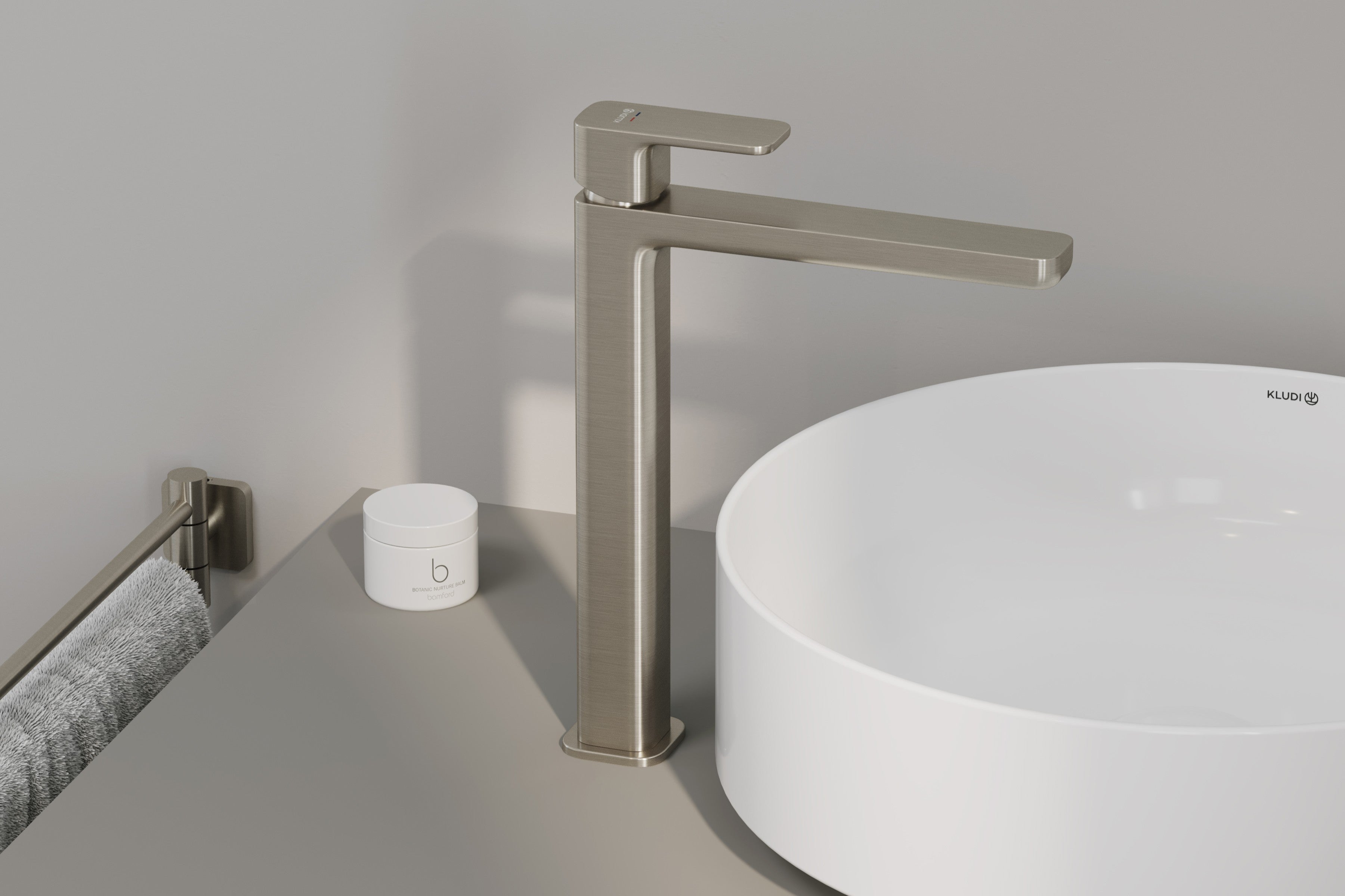 Tall basin mixer in brushed nickel on a split stone block