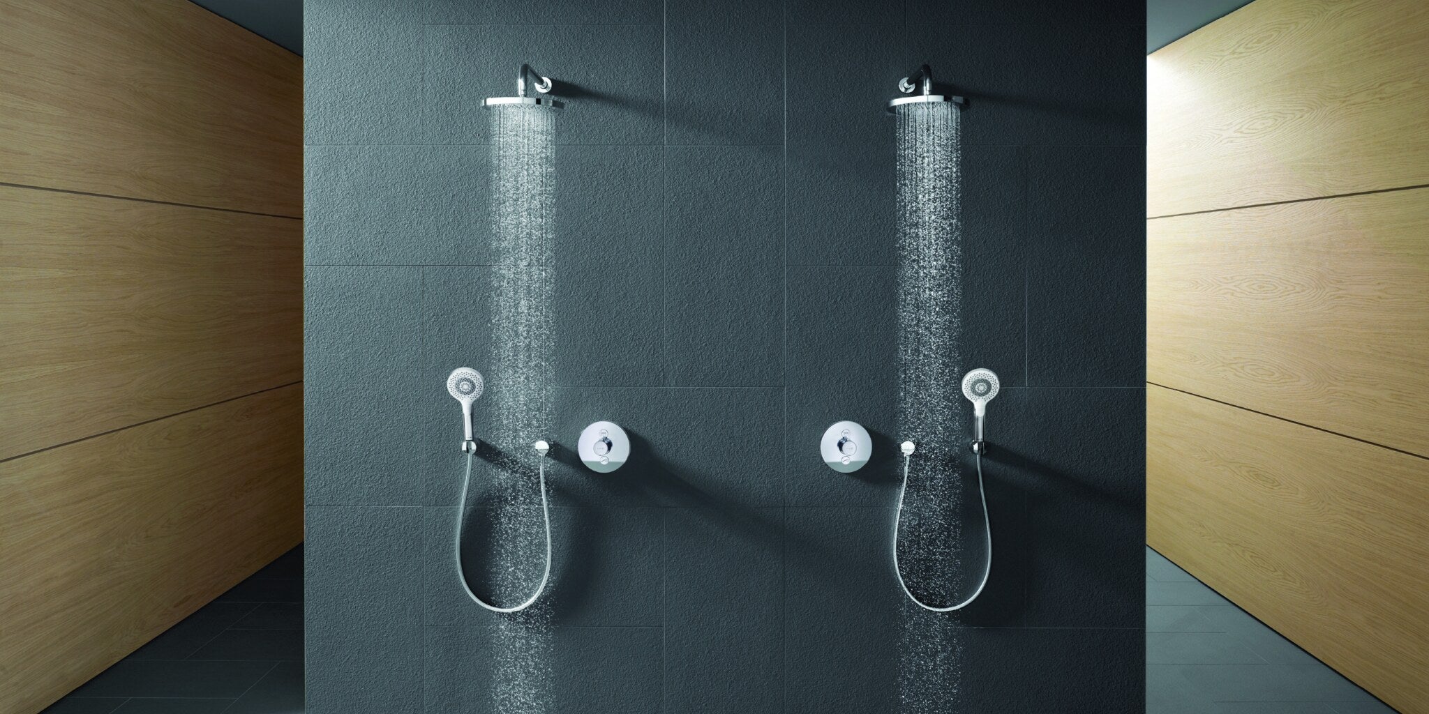 Two shower places side by side on a slate wall, both running