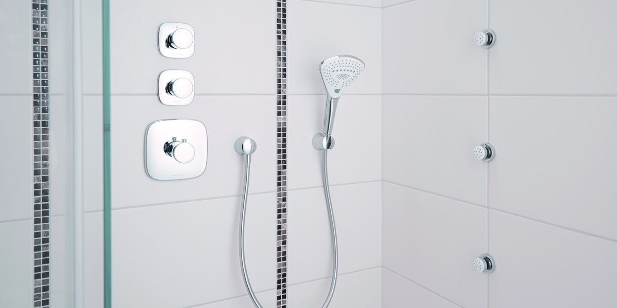 Concealed thermostat with a diverter and a hand shower in a white shower