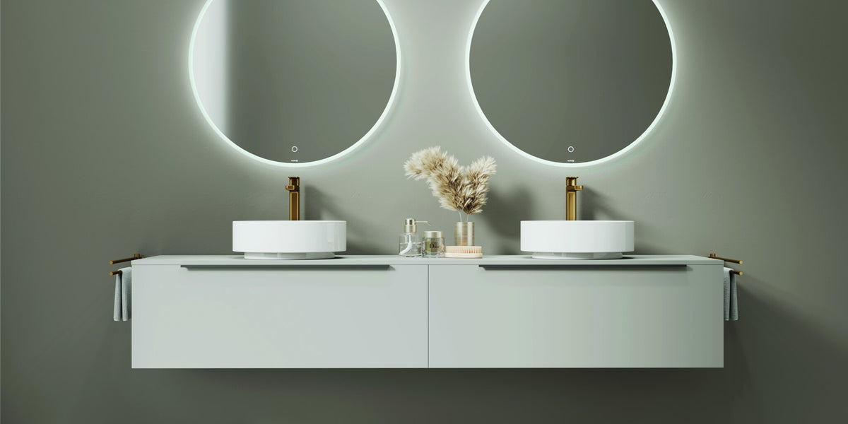 Double vanity unit with twin round backlit mirrors on a green wall