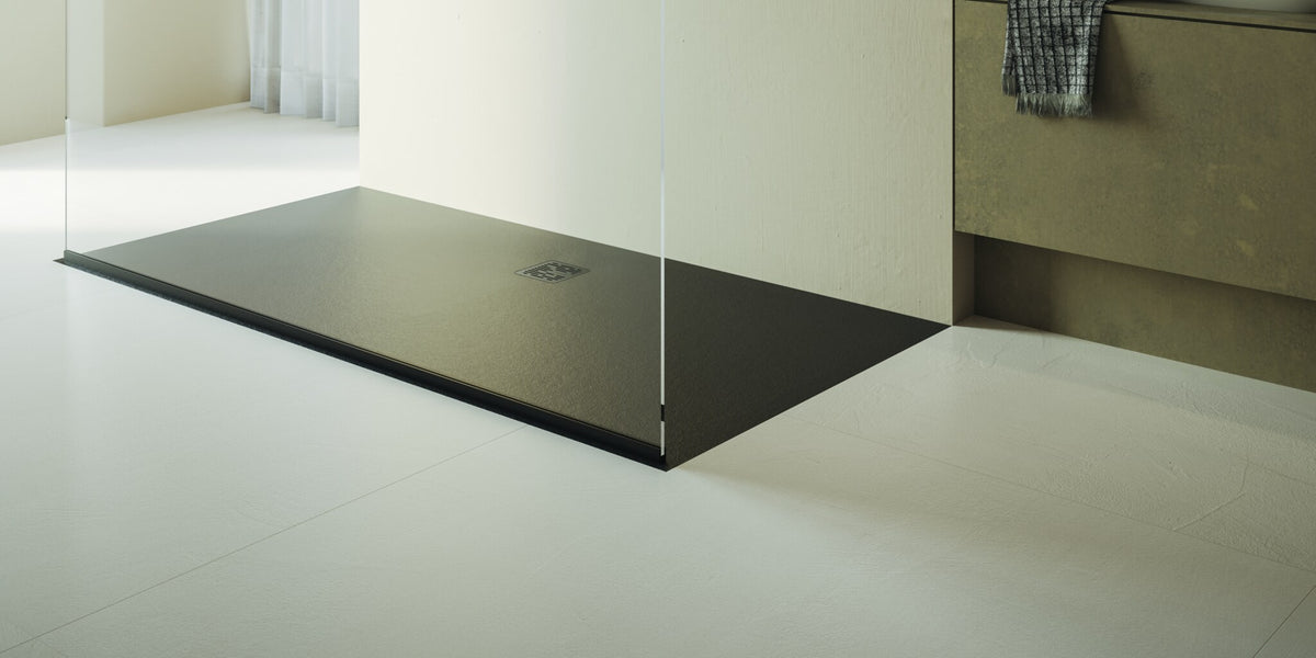 Walk-in shower with a flush dark shower tray beside a vanity