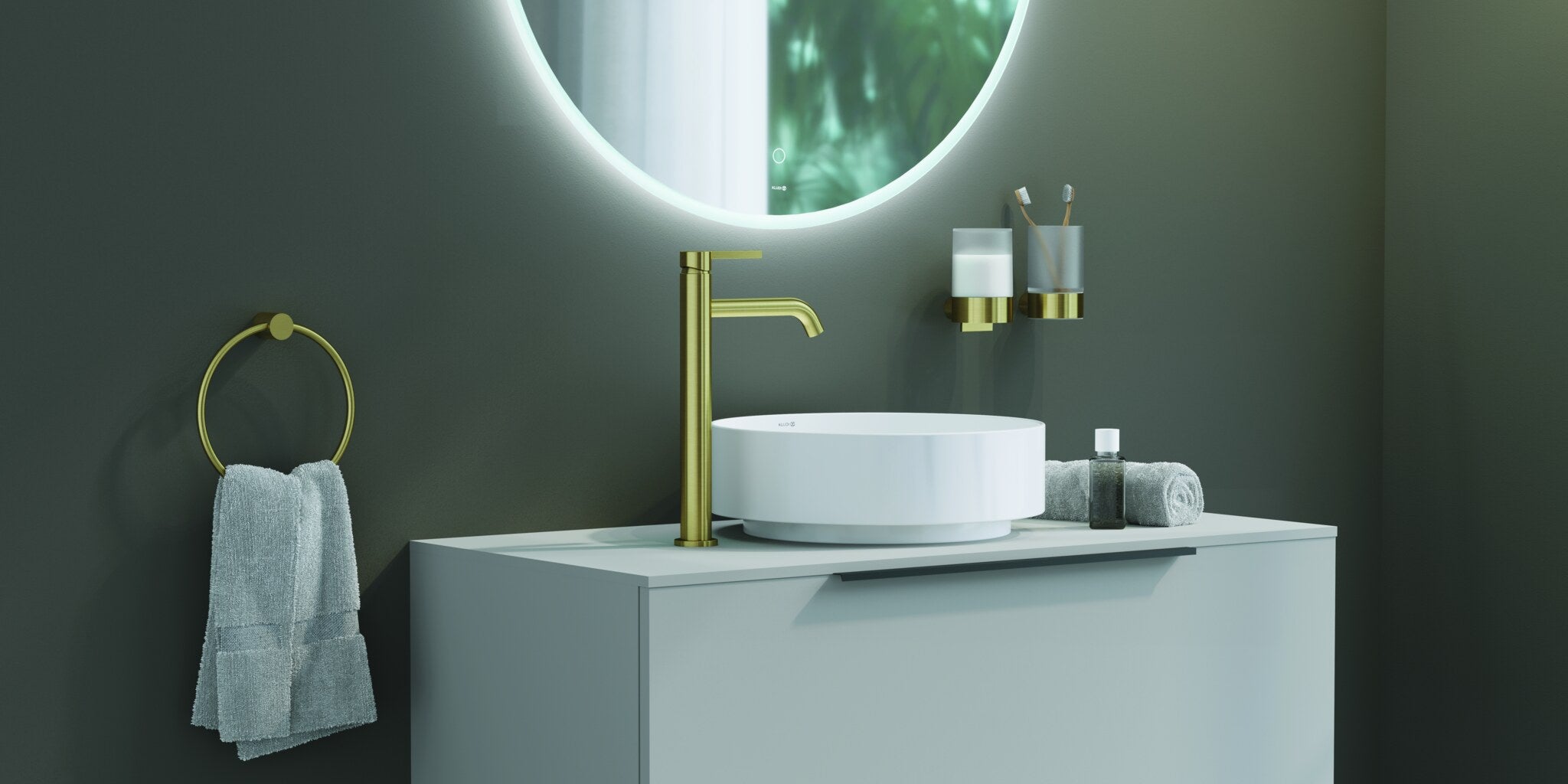 Green bathroom wall with a towel ring, a tumbler holder and a basin mixer in brushed gold