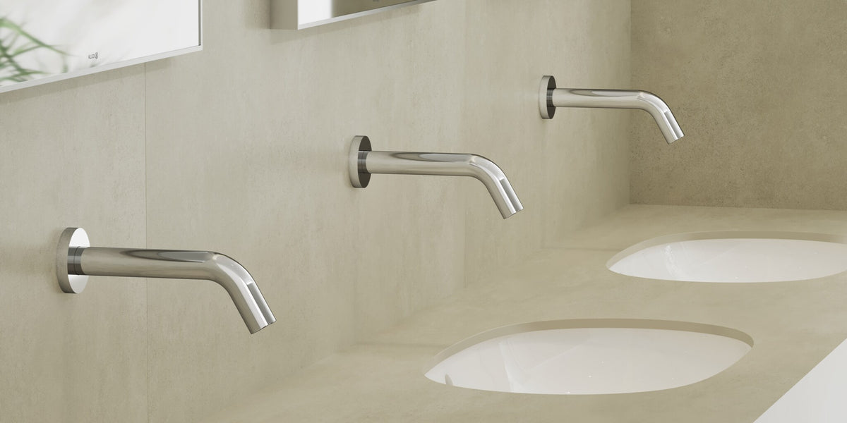 Row of wall-mounted sensor taps over undermount basins in a washroom