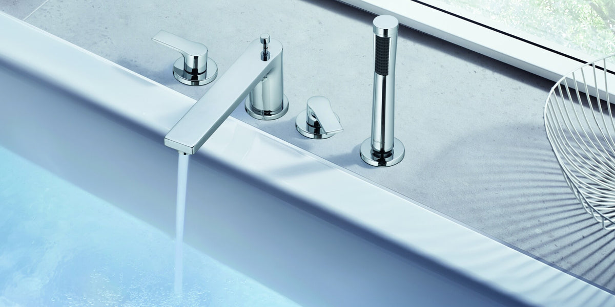 Deck-mounted bath set with hand shower on a stone bath surround